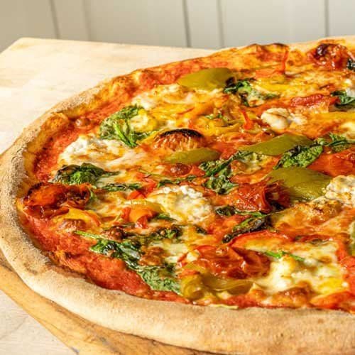 Wood fired pizza topped with cheese, peppers and fresh herbs