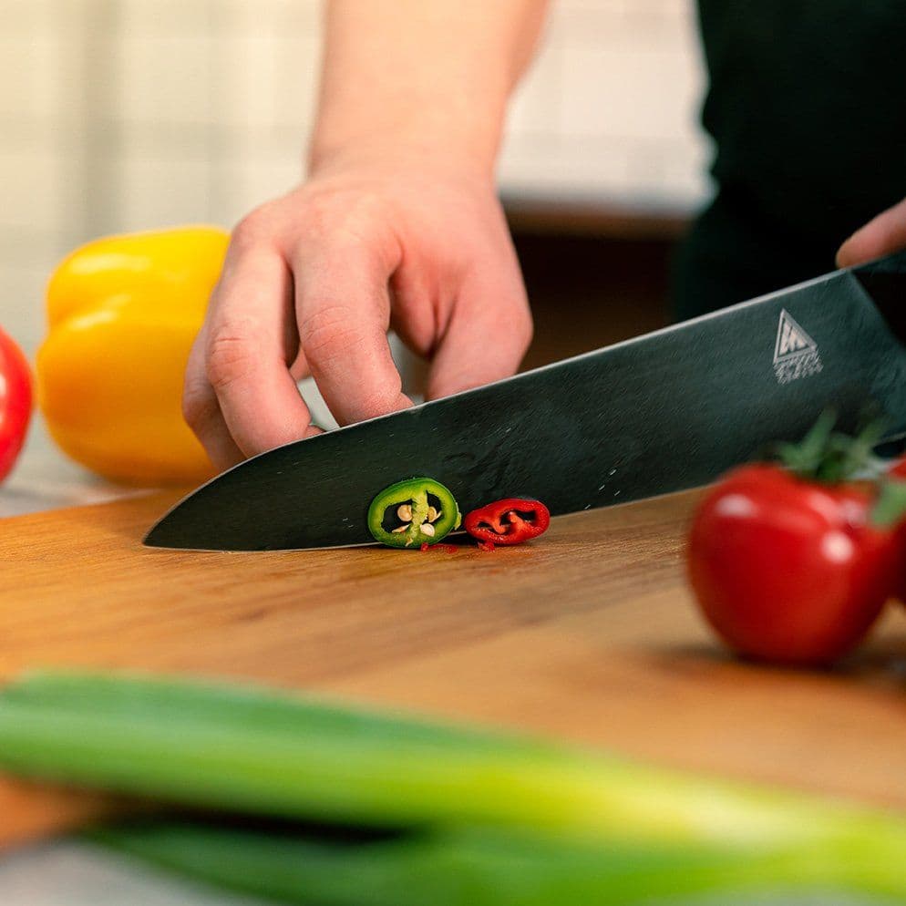A chef chopping fresh peppers, chillies and tomatoes